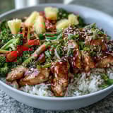 Fork-ready Teriyaki Chicken and Rice Bowl featuring tender chicken glazed in glossy sauce, steamed rice, and crisp broccoli, carrots, and snap peas.