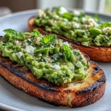 Smoky grilled sourdough bread topped with vibrant fava bean and mint spread.