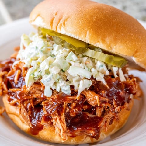 Juicy pulled pork sandwich, piled high on a toasted bun, and drizzled with a rich barbecue sauce.