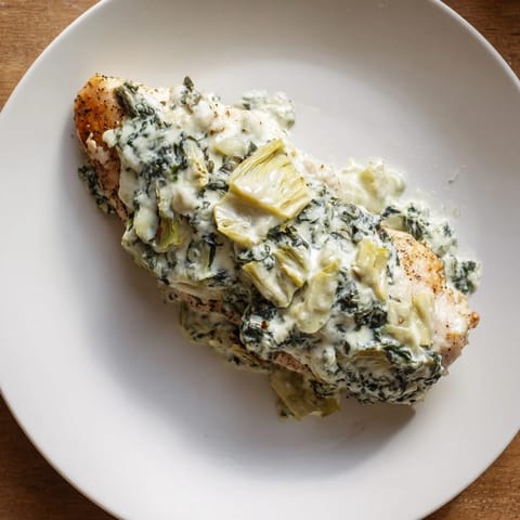 Freshly baked Spinach & Artichoke Chicken Bake with a creamy, golden topping and tender chicken breasts served hot from the oven.  