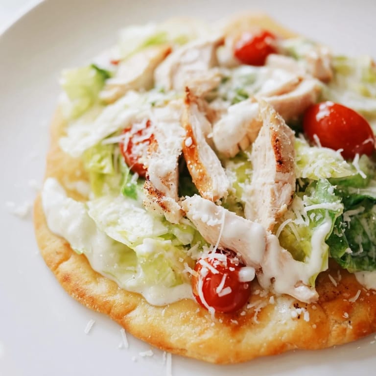Rustic serving of Caesar Chicken Flatbread on a wooden board, garnished with lemon wedges and ready for a family dinner.