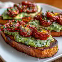 Roasted sweet potato toast with fresh avocado and cherry tomatoes, a vibrant breakfast.