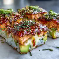 Golden-brown baked Spicy Salmon Sushi Bake served warm in a casserole dish topped with creamy avocado slices.